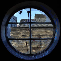 Close-up of cityscape against clear blue sky seen through window