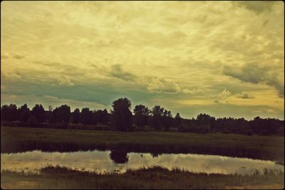 Scenic view of lake against cloudy sky