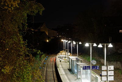 High angle view of railroad tracks by street at night