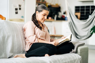 Woman sitting on sofa in book