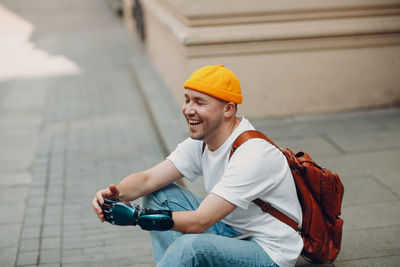 Full length of man wearing hat holding camera