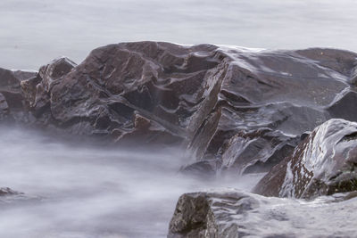 Scenic view of rock formation in sea against sky