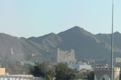 Town by mountains against clear sky