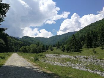 Scenic view of road by mountains against sky