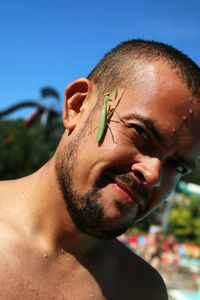 Close-up of praying mantis on man face