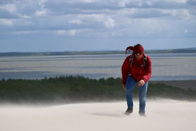 Full length of man standing on sea shore against sky