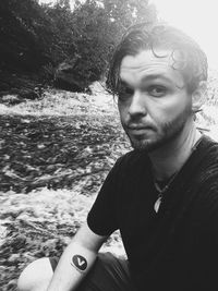 Portrait of young man against water