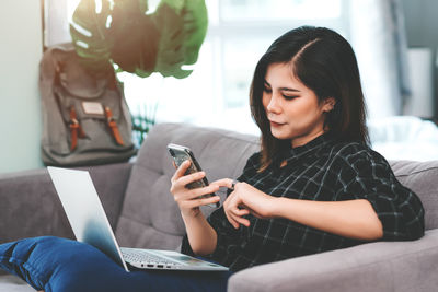 Woman using mobile phone at home