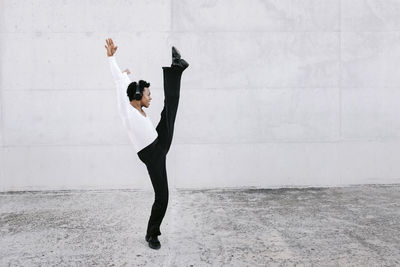 Full length of woman standing against wall