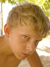 Close-up portrait of shirtless boy at beach