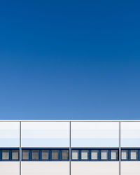 Low angle view of modern building against clear blue sky