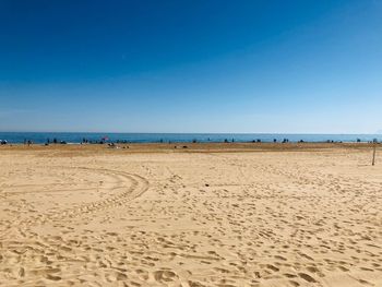 Scenic view of beach against clear blue sky