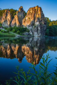 Reflection of rocks in lake against sky