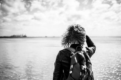Rear view of woman looking at sea against sky