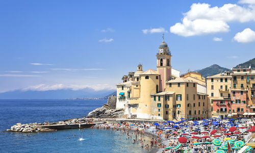 Buildings by sea against sky