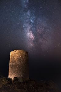 Scenic view of built structure against star field at night