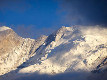 Low angle view of snowcapped mountains against sky