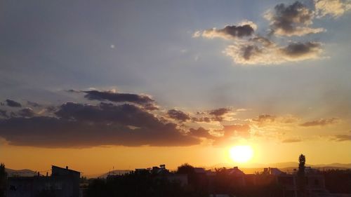 Silhouette buildings against sky during sunset