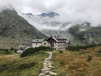 Scenic view of building and mountains against sky