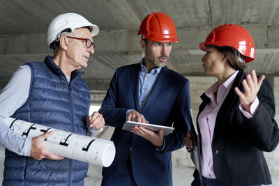 Low angle view of engineers brainstorming at construction site