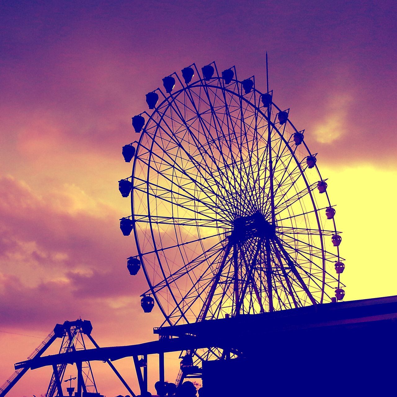 ferris wheel, amusement park, amusement park ride, arts culture and entertainment, low angle view, sky, silhouette, fun, enjoyment, big wheel, sunset, cloud - sky, large, fairground ride, fairground, circle, leisure activity, cloud, traveling carnival, outdoors