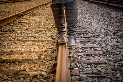 Low section of person walking on railroad track