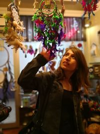 Woman touching dreamcatchers for sale in store
