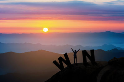 Silhouette people on mountain against sky during sunset