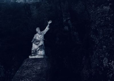 Low angle view of statue against rock