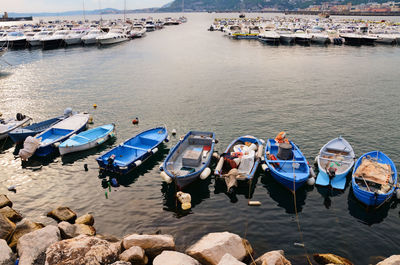 People on boats moored in sea