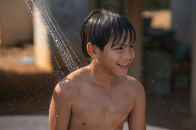 Portrait of shirtless boy in water