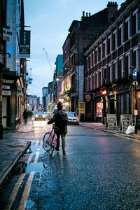 Man walking on street amidst buildings in city