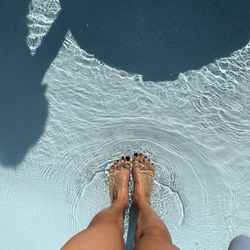 Low section of person legs in swimming pool