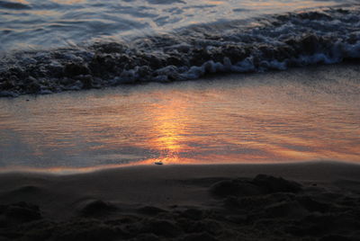 Close-up of sea against sky at sunset