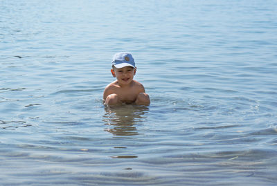 Portrait of shirtless boy swimming in pool