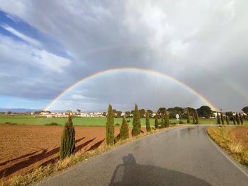 Scenic view of rainbow over field against sky. double rainbow after rainy day. sunny landscape with 