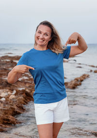 Portrait of a smiling young woman standing on beach