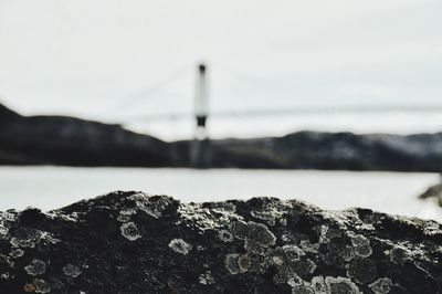 Close-up of rock by sea against sky