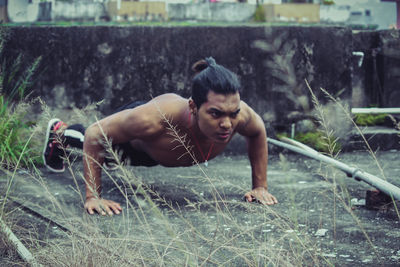 Portrait of shirtless man in grass