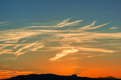 Low angle view of silhouette mountain against dramatic sky