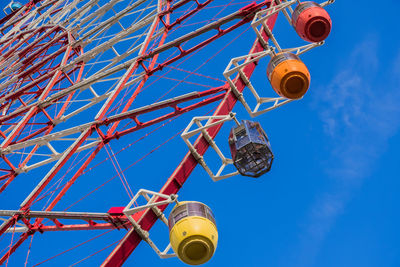 Low angle view of ferris wheel against blue sky