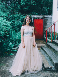 Portrait of smiling bride standing on footpath