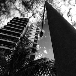 Low angle view of modern building against cloudy sky