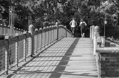 Rear view of people walking on footbridge