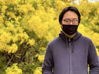 Portrait of young man standing against plants