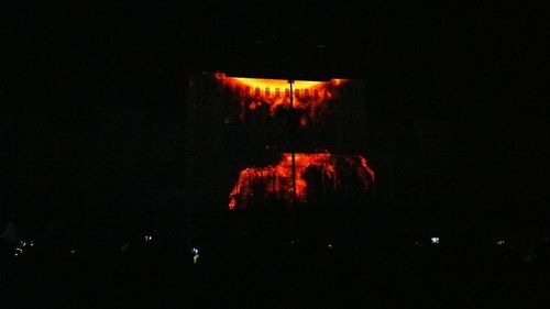 View of lit candle in dark room