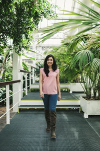 Beautiful agronomical engineer walking through the greenhouse