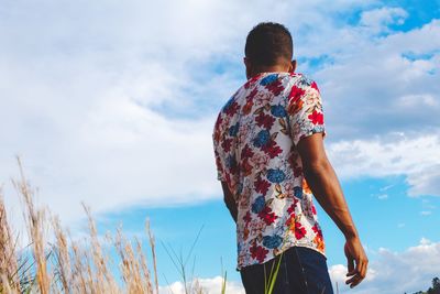 Rear view of a man looking sideways at the sky