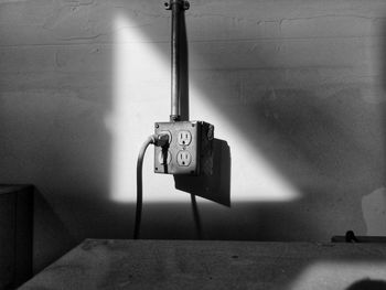 Close-up of telephone pole against wall at home