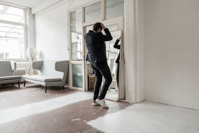 Rear view of businessman looking in mirror